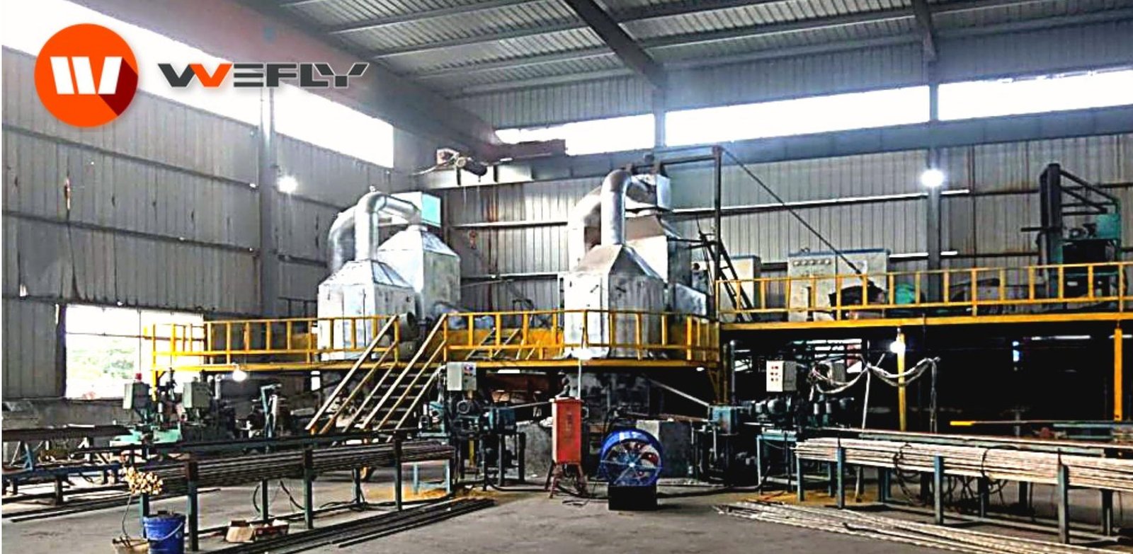 WOLFU brass rod horizontal continuous casting machine running in a factory workshop, with melting furnace and safety railings.